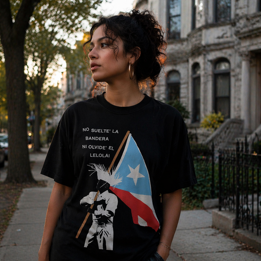 Woman wearing a Le Lo Lai Puerto Rican flag black t-shirt, standing on a sidewalk.